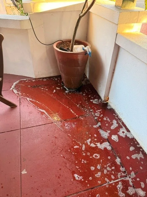 Red tiled courtyard being scrubbed by hand with cleaning solution
