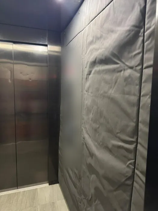 Grey protective blankets hung inside a lift for a resident move in