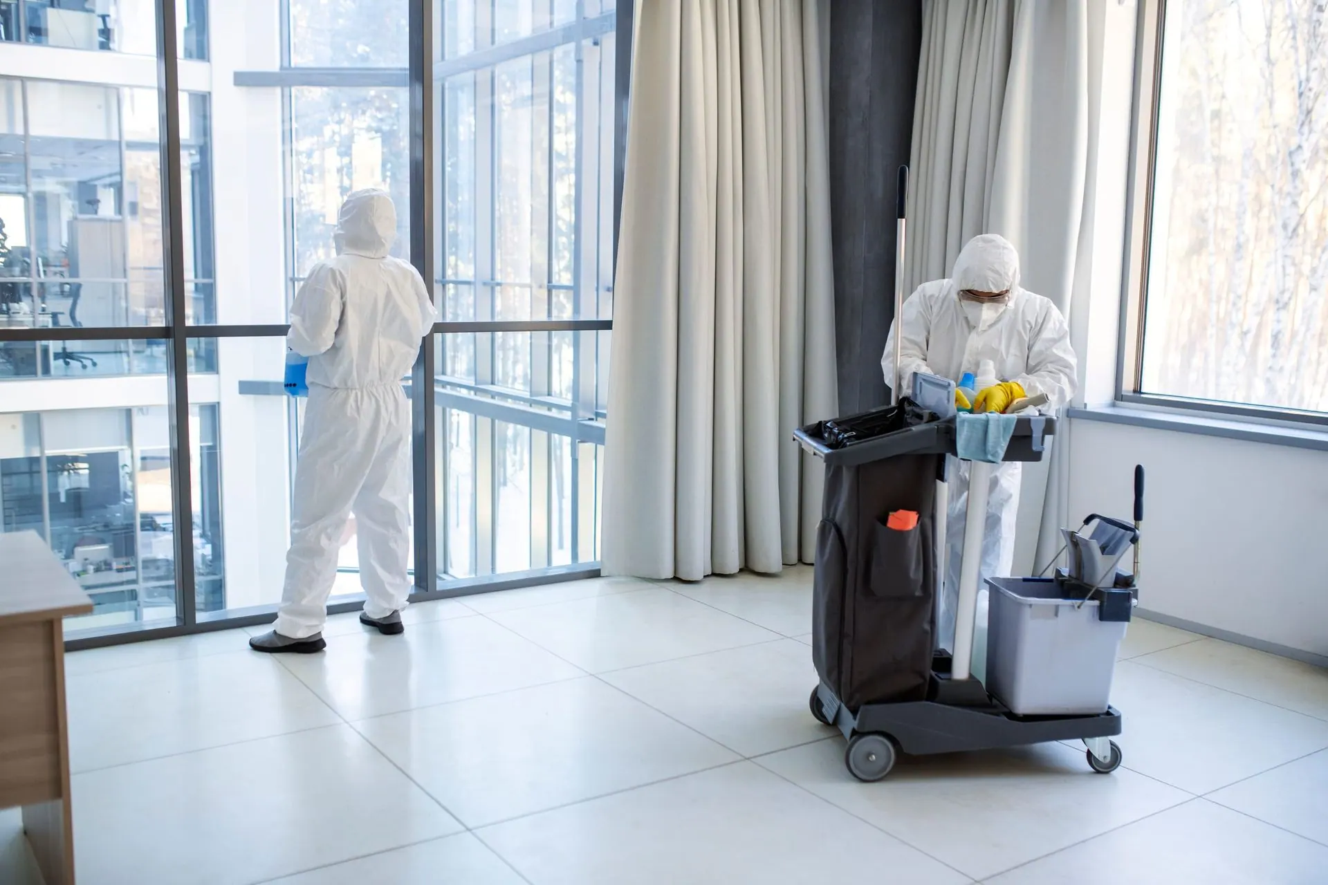 Deep cleaning team in protective equipment carrying out a thorough facility clean