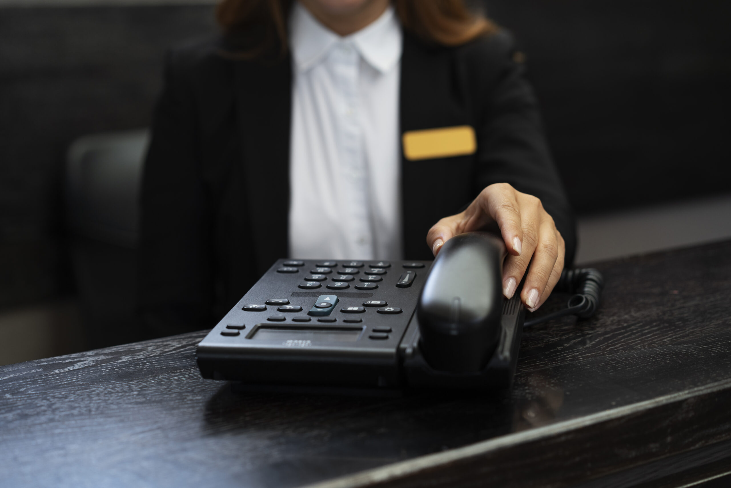 Concierge receptionist in elegant uniform assisting a resident at the front desk