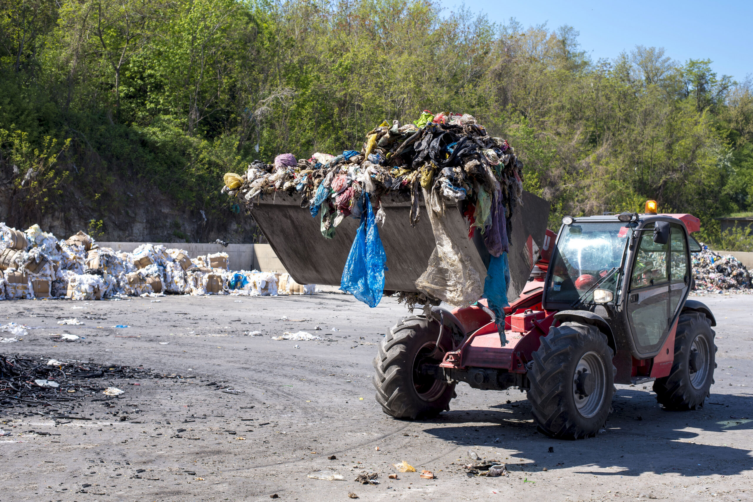 Wheel loader transporting waste at a waste treatment facility